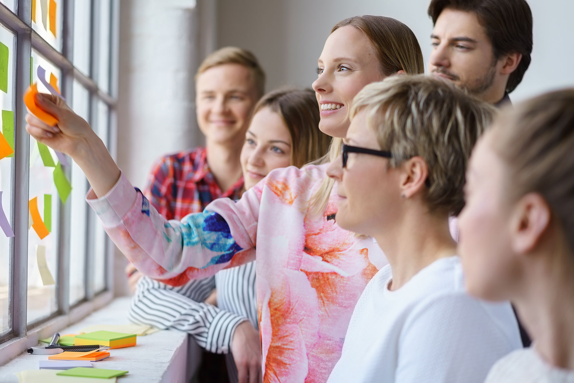 Gruppe von sechs Menschen arbeitet mit Haftnotizen