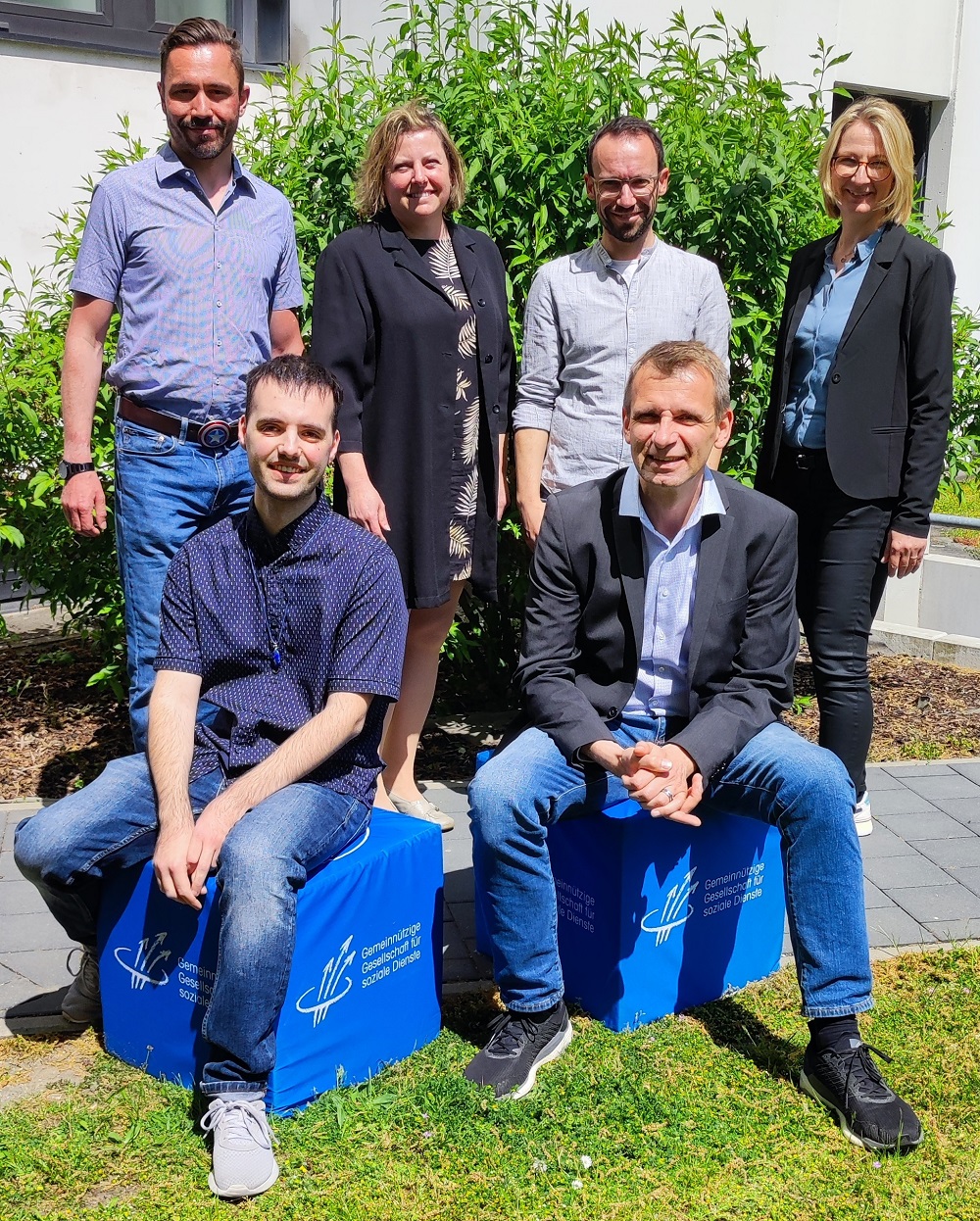 Victor Jurjac (vorne links) mit seinem Mentor Günther Heil (vorne rechts), Access-Jobcoach Thomas Dirr (stehend, 2.v.r.) und Kolleg*innen am GGSD Bildungszentrum in Nürnberg Langwasser (vlnr): Schulleiter Rudolf Klug, SFW Leiterin Katja Bielig, SFW Mitarbeiterin Fanny Link.